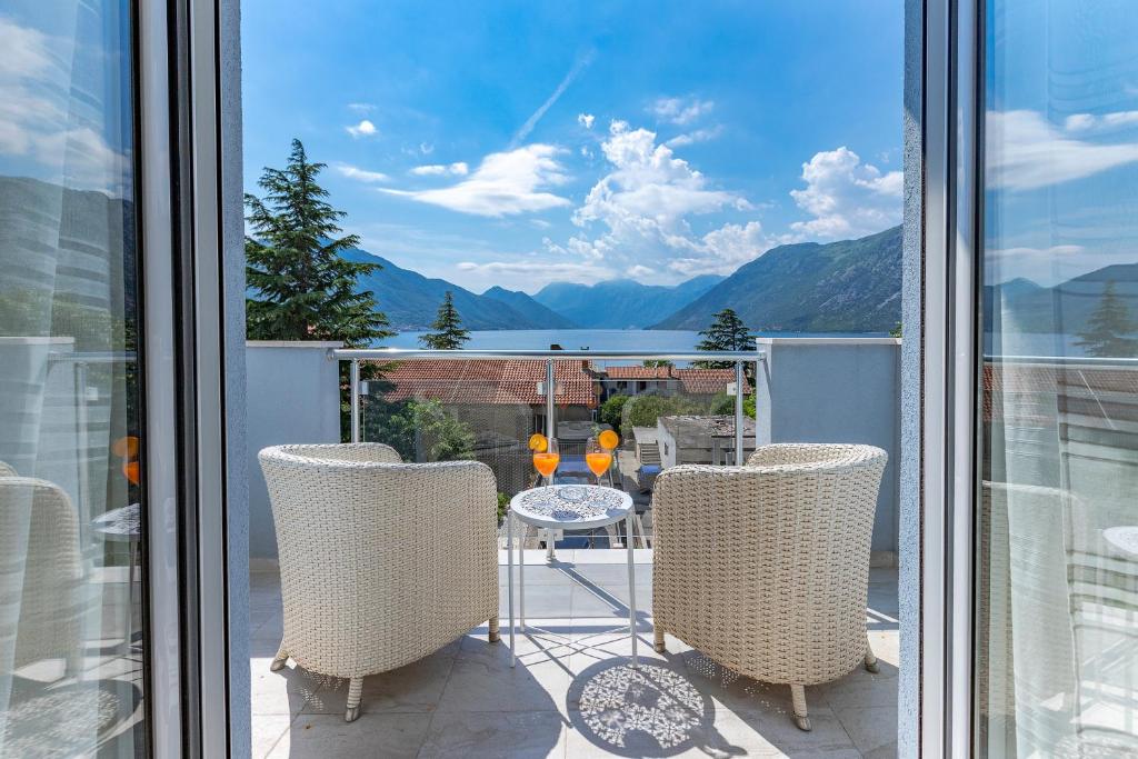 uma mesa e cadeiras numa varanda com vista em Apartments Stetonn em Kotor