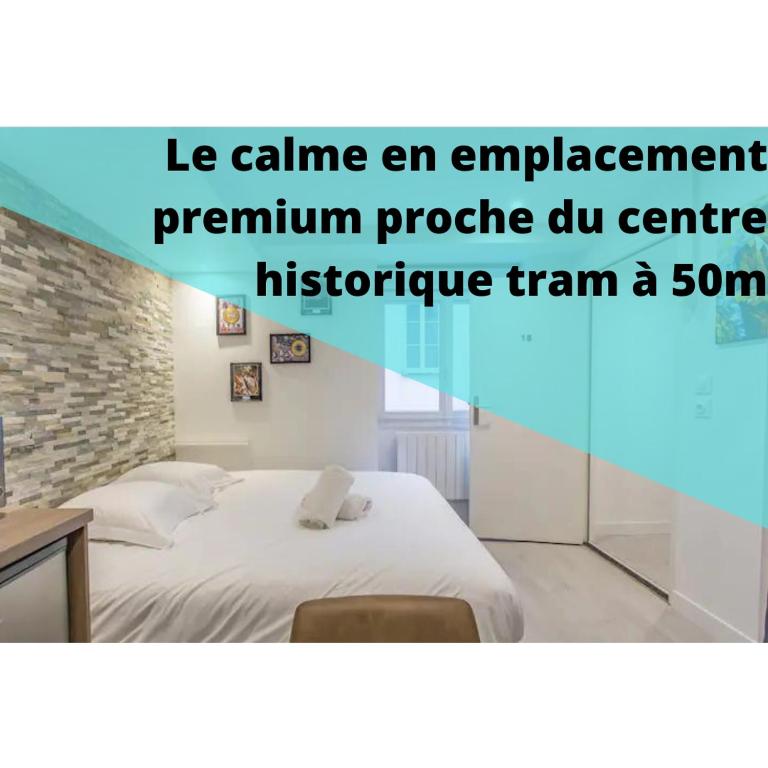 une chambre avec un lit blanc et un mur de briques dans l'établissement R’Studio 18 Hyper Centre, à Grenoble