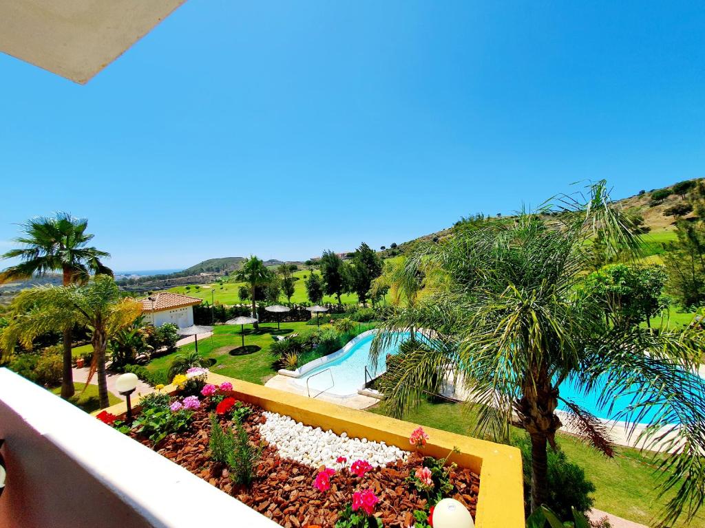 uma varanda com vista para uma piscina e uma palmeira em Casa Laarne em Mijas
