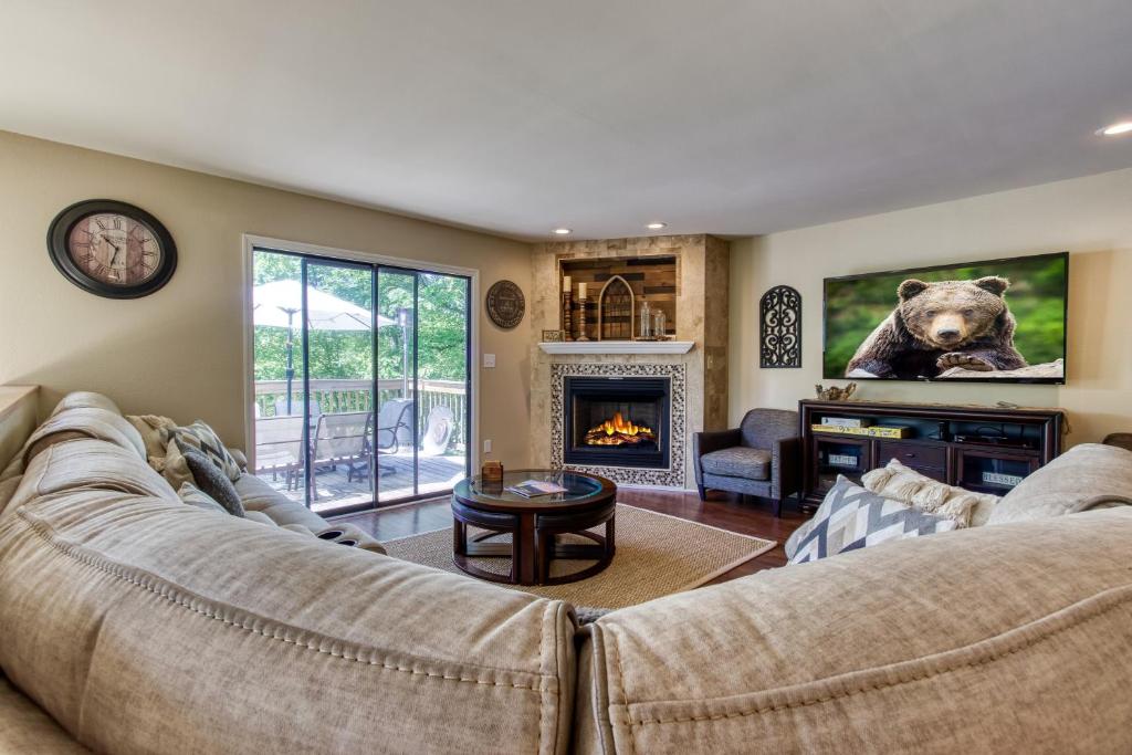 a living room with a couch and a fireplace at Memorable "Deer & Doe" by HoneyBearCabins 4BR 3BA, Mountain View Deck, Farmhouse Decor, Fireplace, 3 Acres in Sevierville