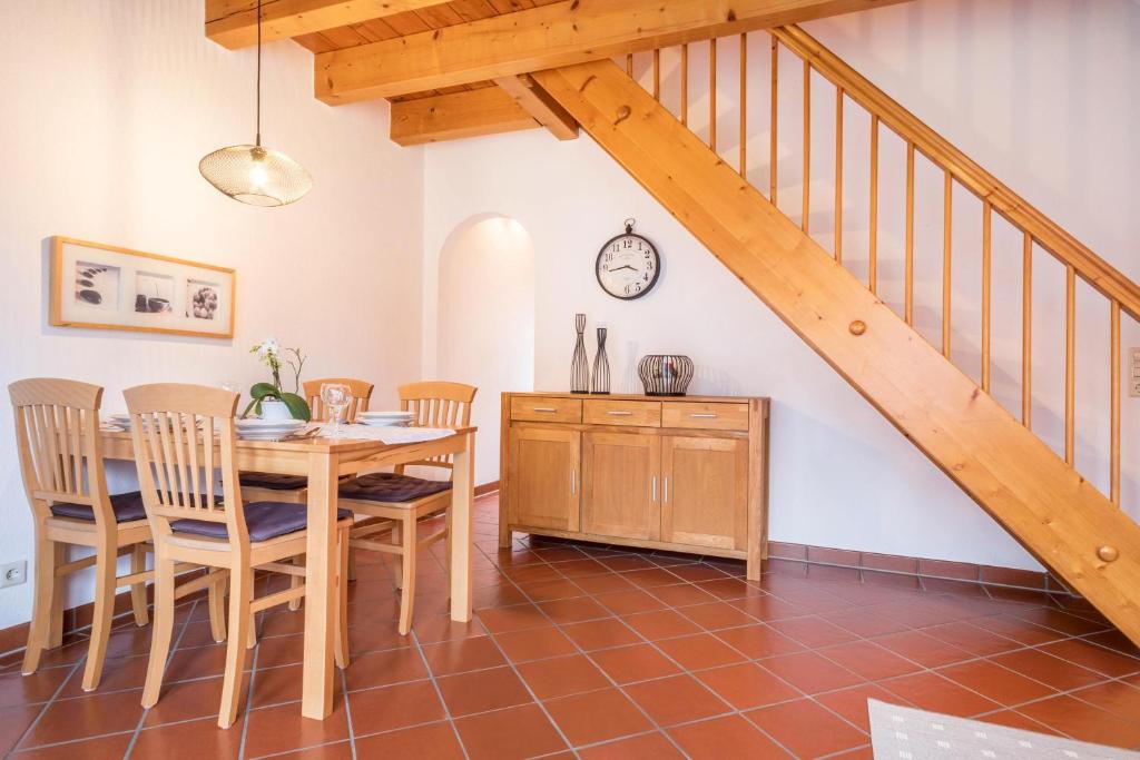 un comedor con mesa y sillas y una escalera en Gästehaus Heilig Apartment 3, en Langenargen