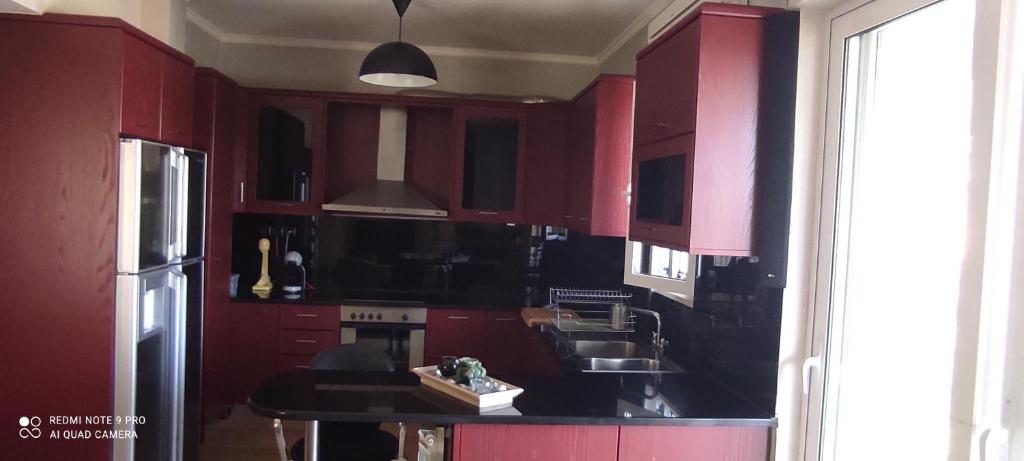 una cucina con armadi rossi e piano di lavoro nero di The Hammam Guest House a Nydri