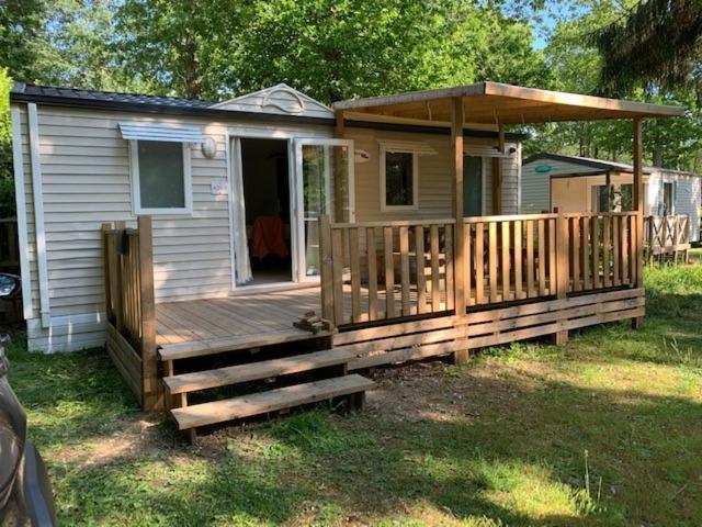 Cette petite maison dispose d'une terrasse couverte et d'une terrasse en bois. dans l'établissement Mobil-Home Saint Cheron, à Saint-Chéron
