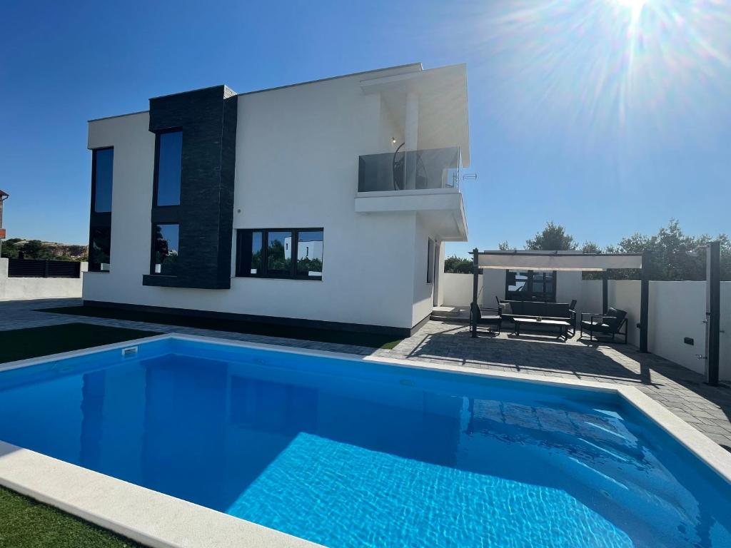 a villa with a swimming pool in front of a house at Villa Eureka in Vodice