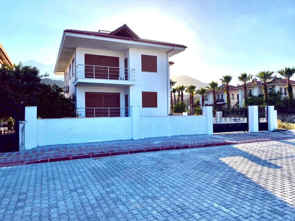 a white house with a brick driveway in front of it at Kemer Guney Homes Apart in Kemer