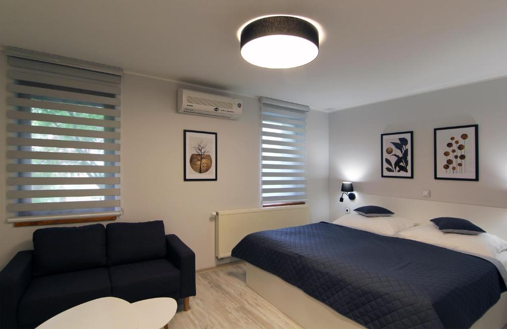 um quarto com uma cama e um sofá preto em Penzion U Vlků em Valtice