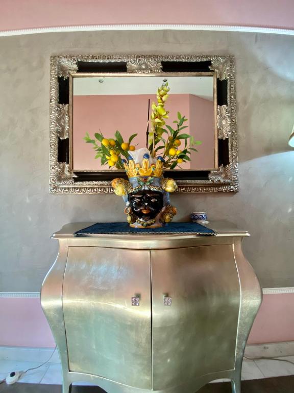 a vase with flowers on a table in front of a mirror at Hotel Scilla in Scilla
