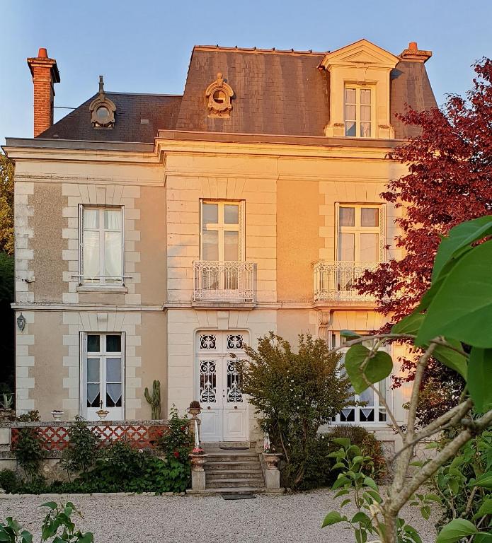 une grande maison jaune avec une porte blanche dans l'établissement LA MAISON LEONARD, à Bléré