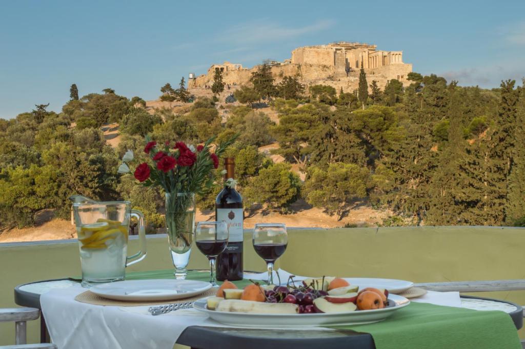 een tafel met een bord eten en een glas wijn bij Meros - Athenian Residencies in Athene