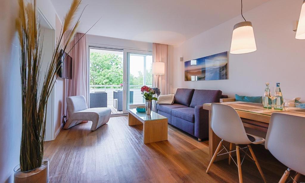 ein Wohnzimmer mit einem blauen Sofa und einem Tisch in der Unterkunft Blue Sky in Dierhagen