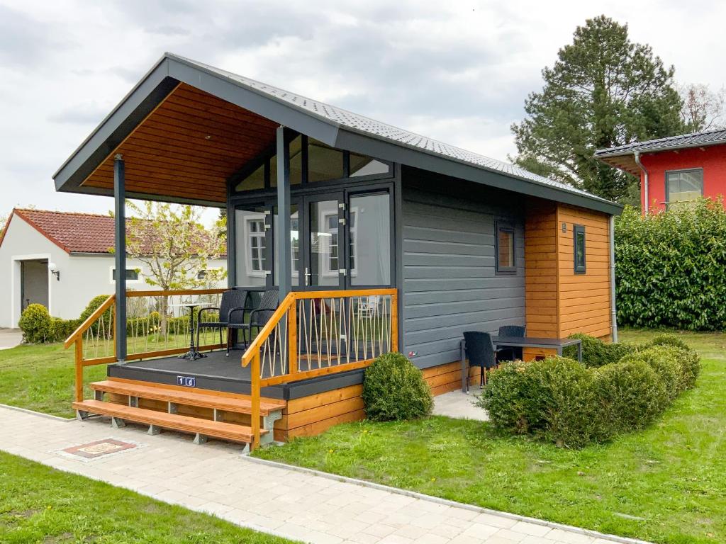 una casa pequeña con una terraza grande en un patio en Tiny House 1d, en Varel