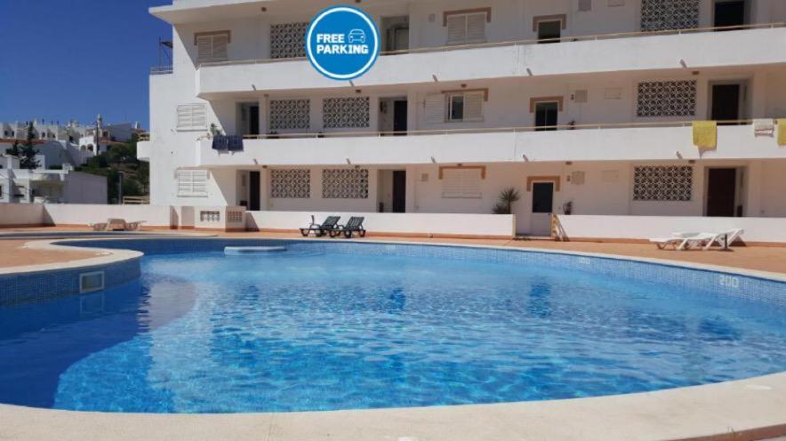 une grande piscine en face d'un bâtiment dans l'établissement Carvoeiro Beach and Pool, à Carvoeiro