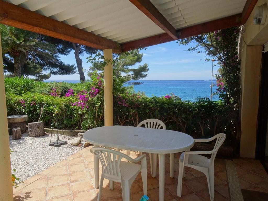 une table et des chaises sur une terrasse avec vue sur l'océan dans l'établissement Beau 2 pièces avec vue mer en terrasse face plage de Gigaro, à La Croix-Valmer