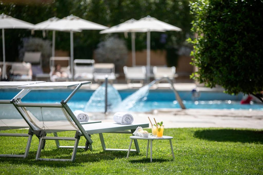 a table and a chair next to a swimming pool at Silva Hotel Splendid in Fiuggi