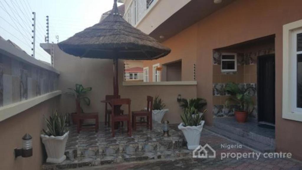 une terrasse avec des chaises et un parasol dans une maison dans l'établissement luxury 4 bed rooms duplex lekki Lagos nigeria, à Lekki