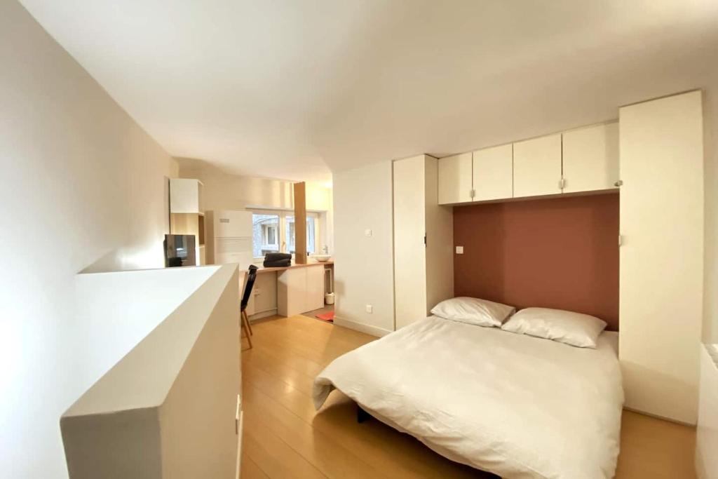 a small bedroom with a bed and a kitchen at Studio Zen Tokyo in Lyon