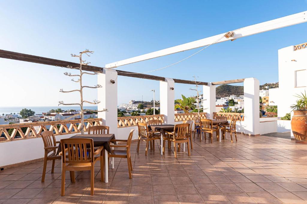 a patio with tables and chairs on a roof at Hostal El Dorado in San José