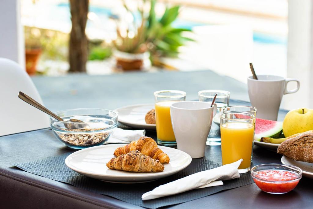 a table with plates of food and glasses of orange juice at Hostal El Dorado in San José