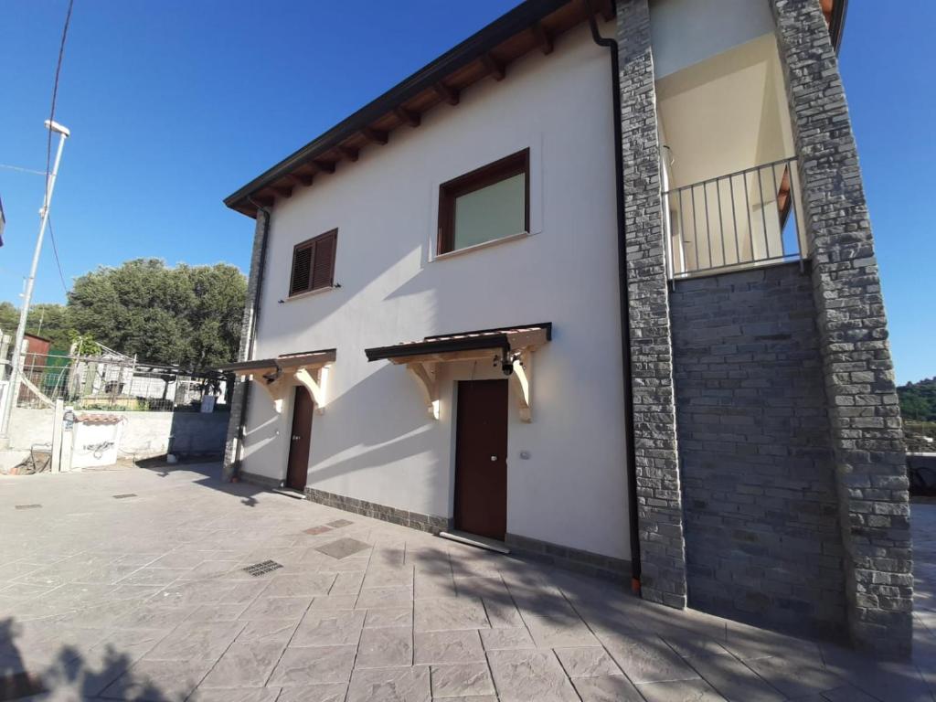 Edificio blanco con puerta y balcón en Casa Vacanze Palinuro-Mare, en Palinuro