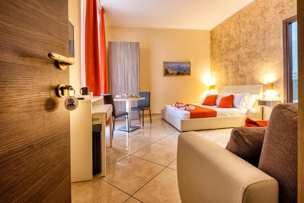 Habitación de hotel con cama y sala de estar. en Re Diego en Nápoles