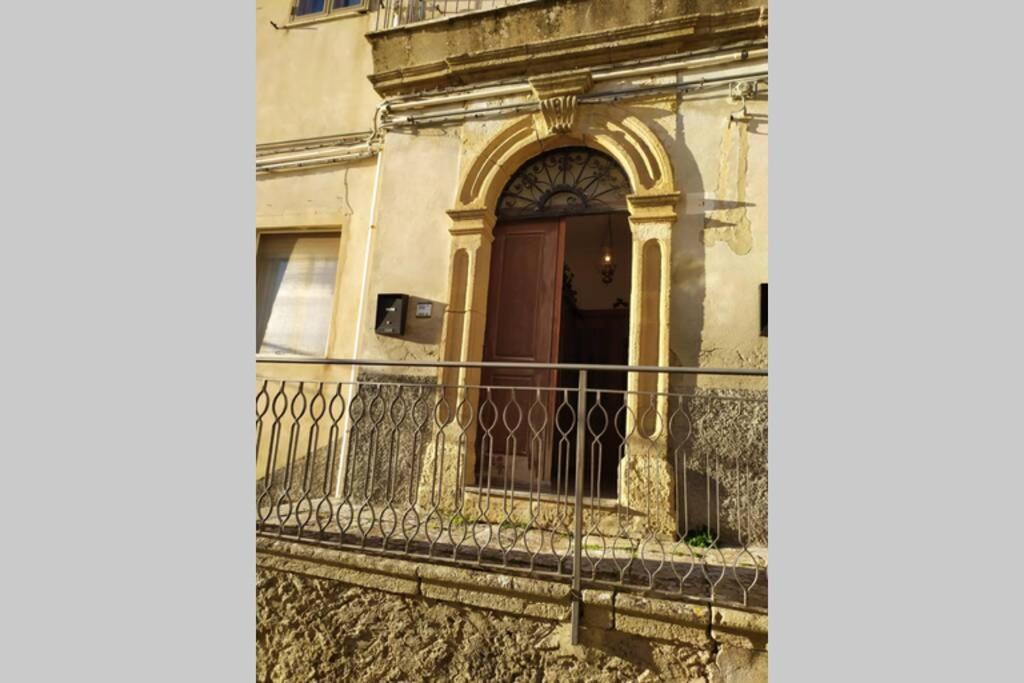 a building with a balcony with a door at Casa ad Assoro, al centro della Sicilia in Assoro