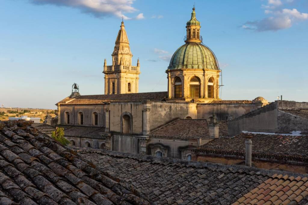 un ancien bâtiment avec une tour d'horloge et des toits dans l'établissement MenzaTesta - Casa indipendente con terrazzo, à Raguse