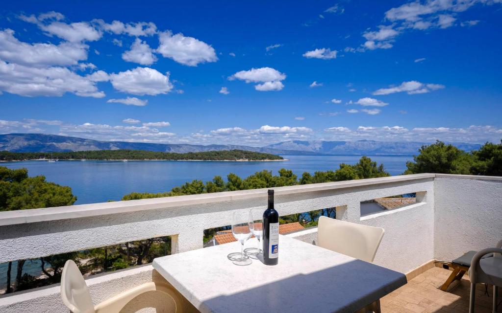 - une bouteille de vin assise sur une table sur un balcon dans l'établissement Apartments Poklepović, à Jelsa