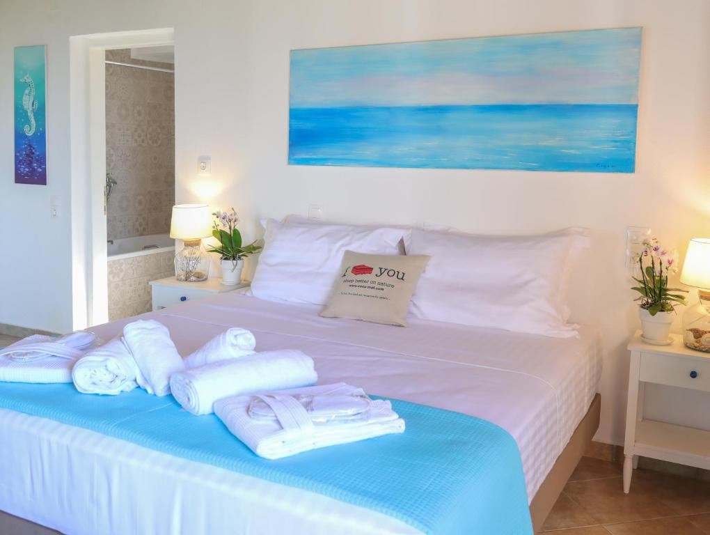a bedroom with a bed with towels on it at Georgia Villas in Skiathos
