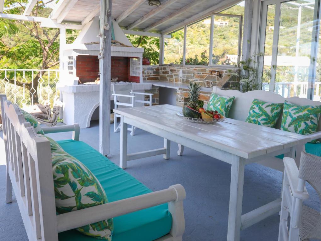 a table and chairs on a patio with a fireplace at Georgia Villas in Skiathos