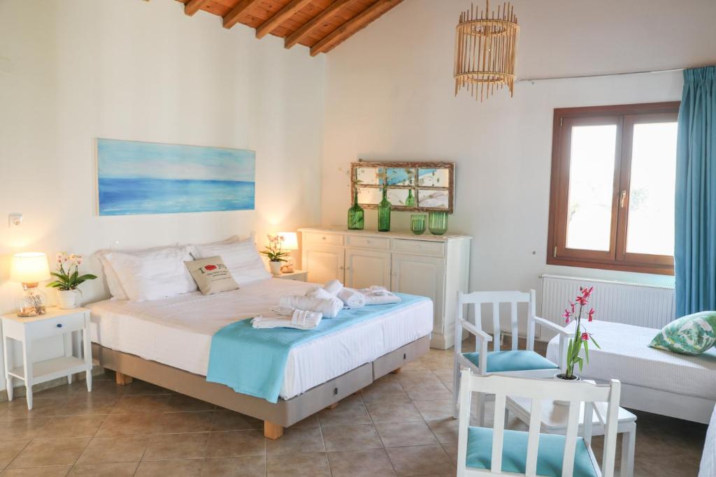 a bedroom with two beds and two chairs at Georgia Villas in Skiathos