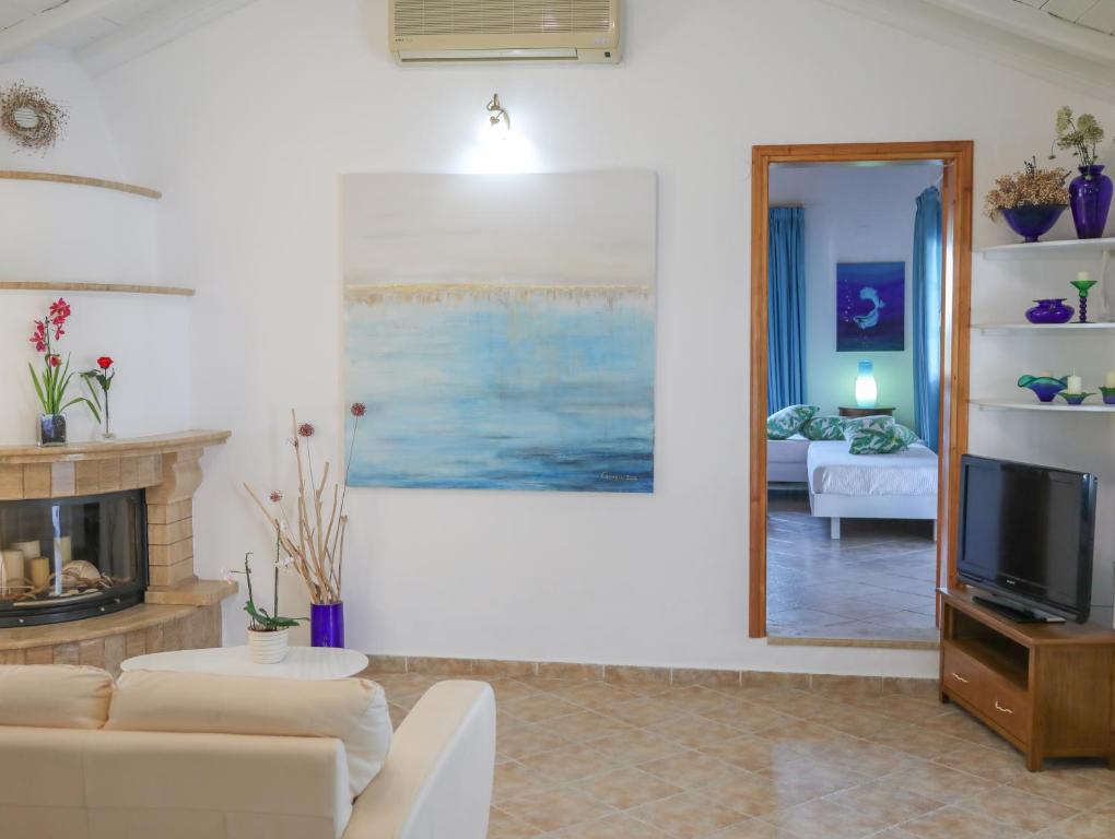 a living room with a fireplace and a television at Georgia Villas in Skiathos