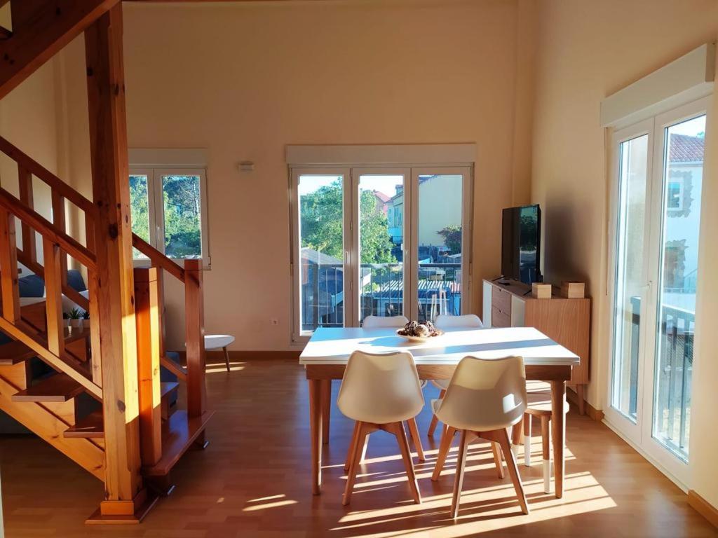 eine Küche mit einem Tisch und Stühlen im Zimmer in der Unterkunft Duplex Playa Langosteira in Kap Finisterre