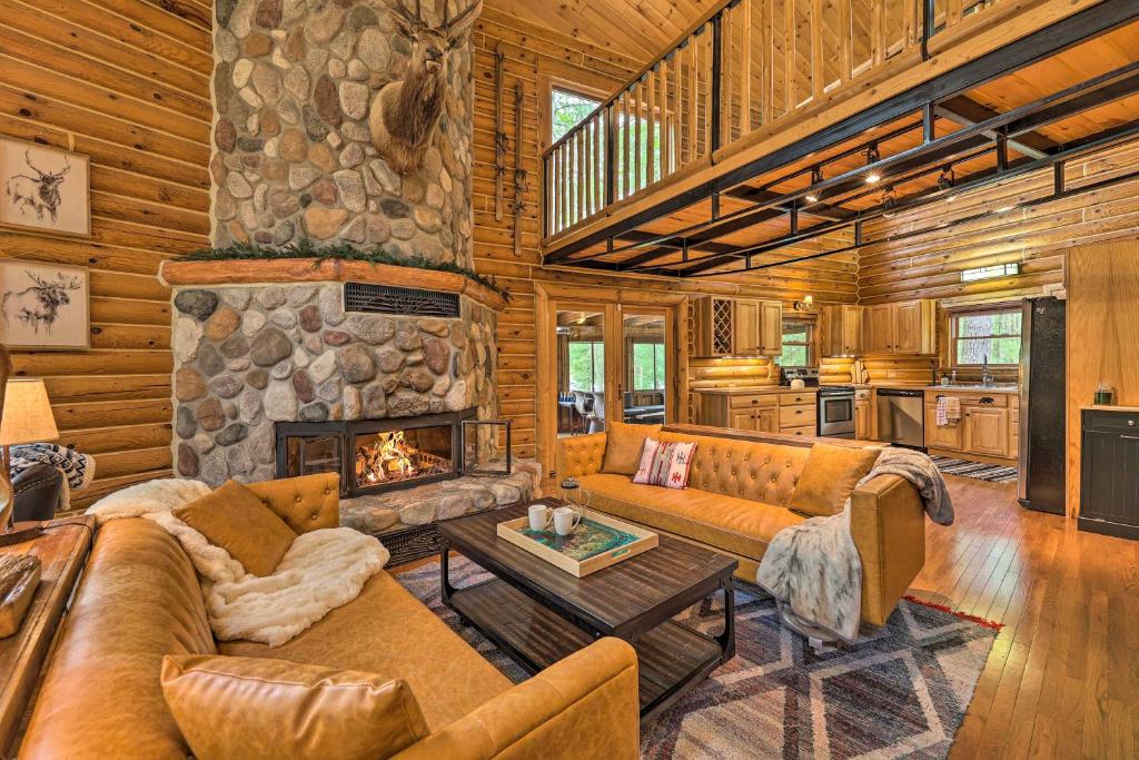 ein Wohnzimmer mit Sofas und einem Steinkamin in der Unterkunft Luxe Riverfront Lodge by Torch Lake with Kayaks in Rapid City