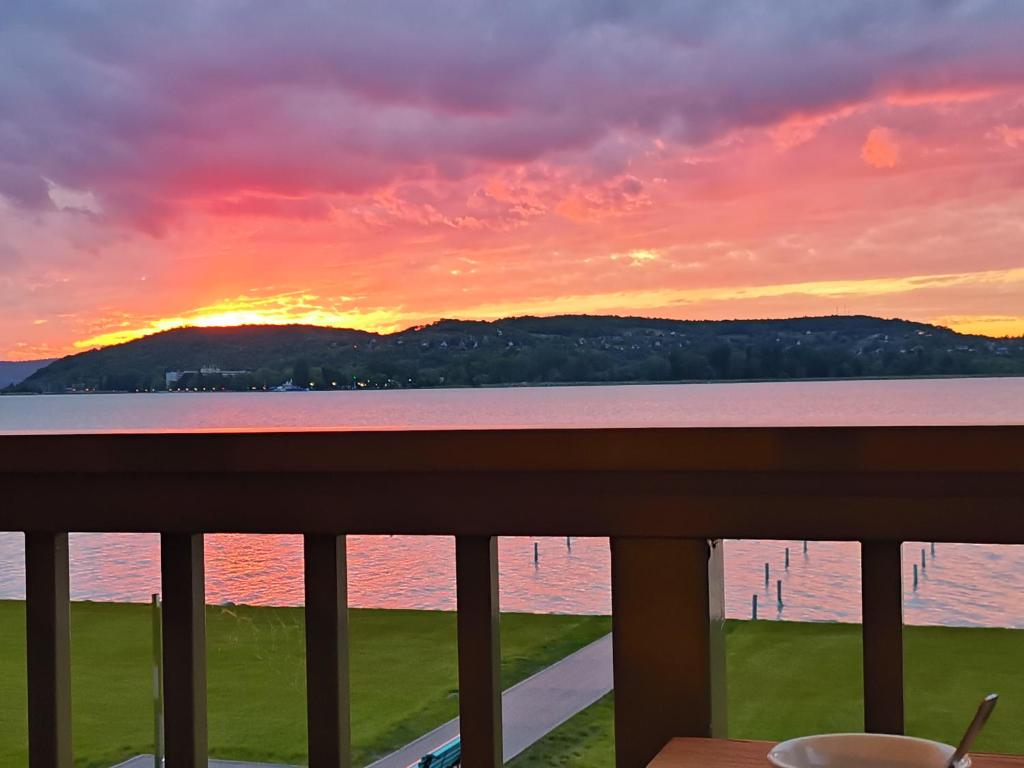 a sunset from the balcony of a condo at Vízparti luxus apartman Szántód in Szántód