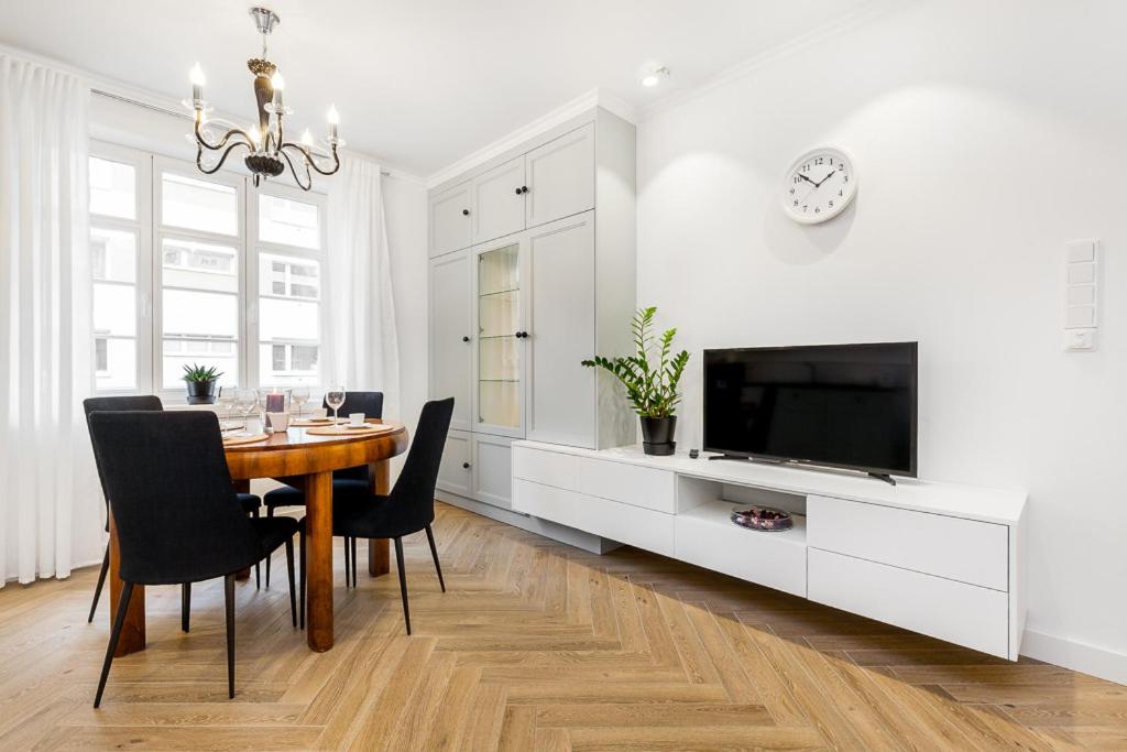 a dining room with a table and a tv at Holiday Sopot Apartment in Sopot