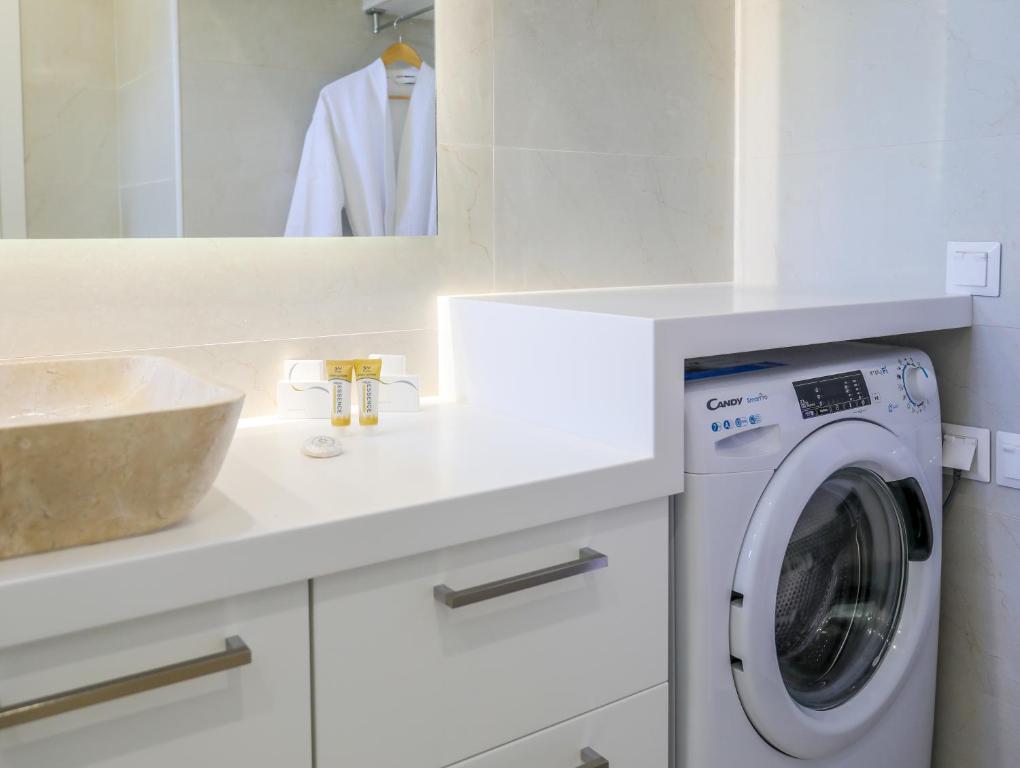 a white bathroom with a washing machine and a sink at Georgia Villas in Skiathos