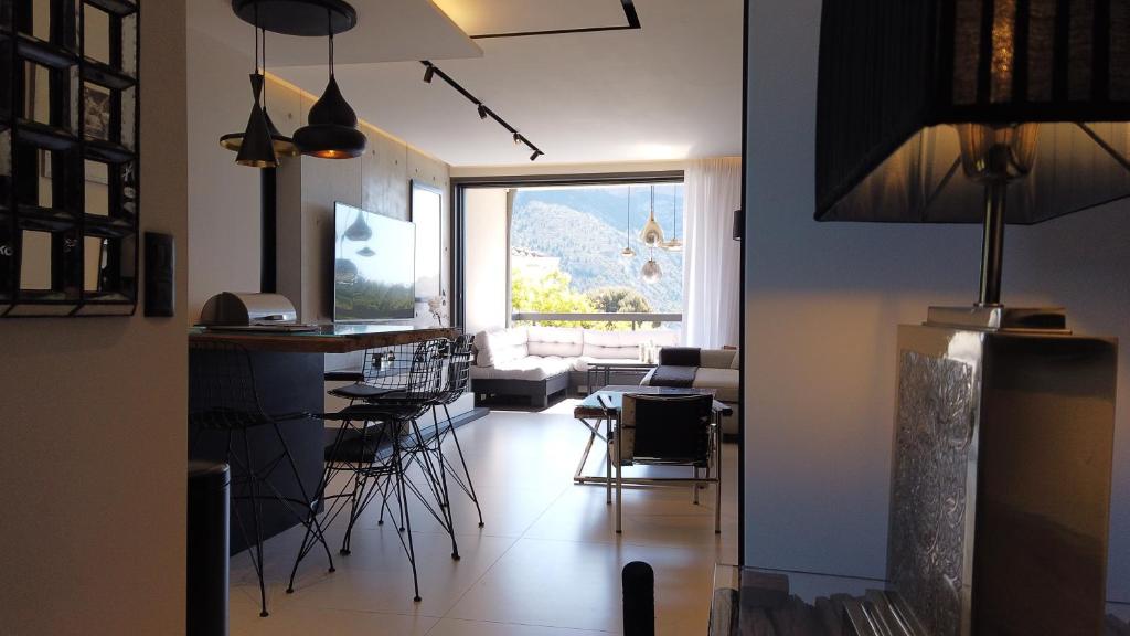 d'un salon avec une table, des chaises et une fenêtre. dans l'établissement Appartement Villa Cassis, à Cassis