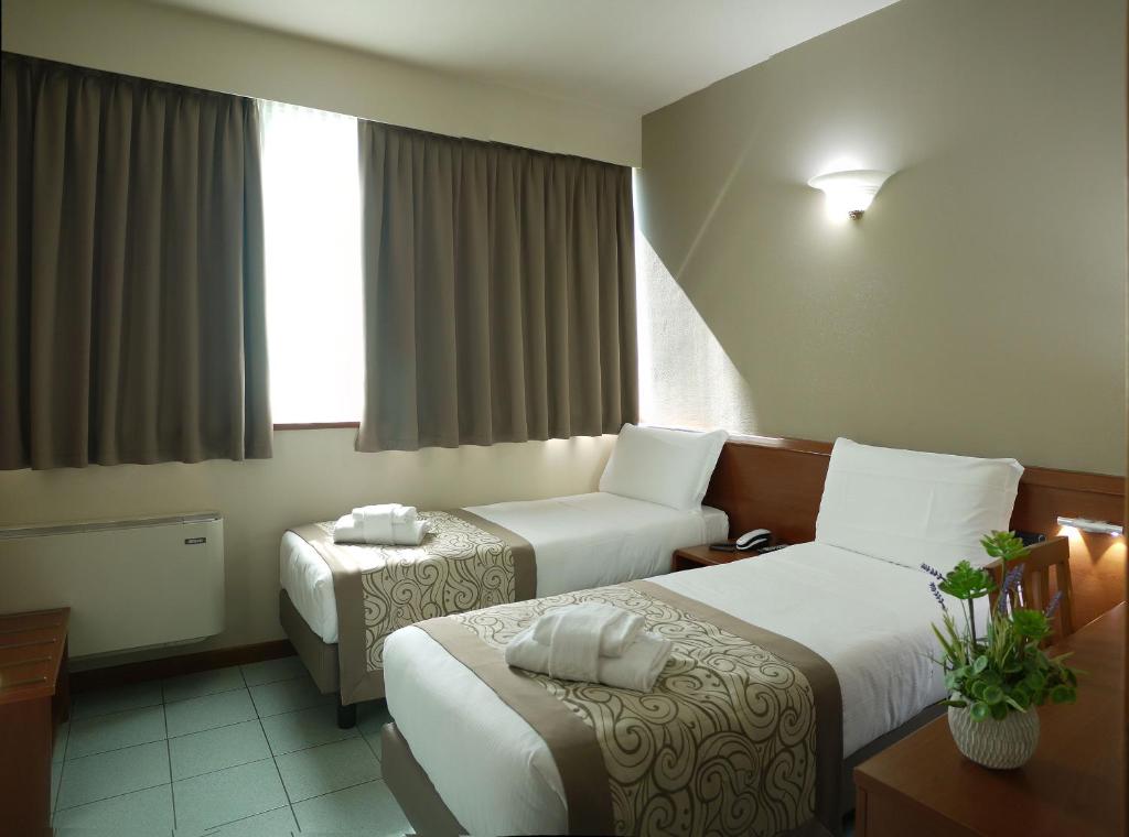 Postel nebo postele na pokoji v ubytování ALA Hotel
