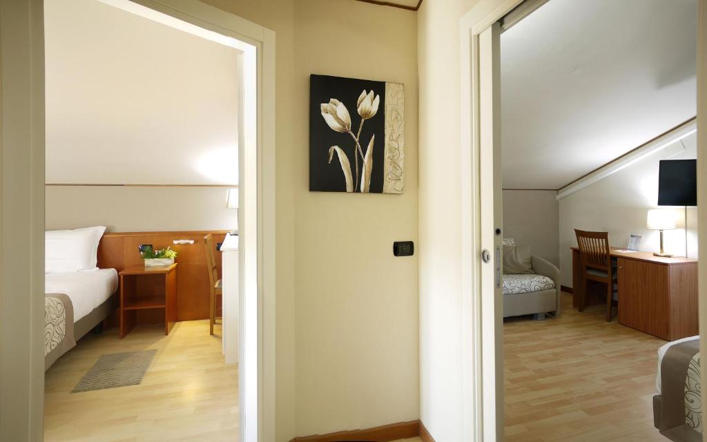 Postel nebo postele na pokoji v ubytování ALA Hotel