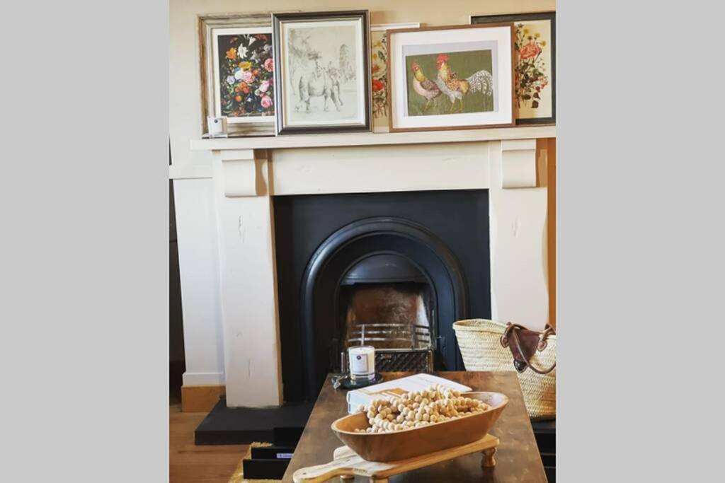 a living room with a fireplace and a table with a bowl of food at Mary-Jane’s Cottage in Omagh