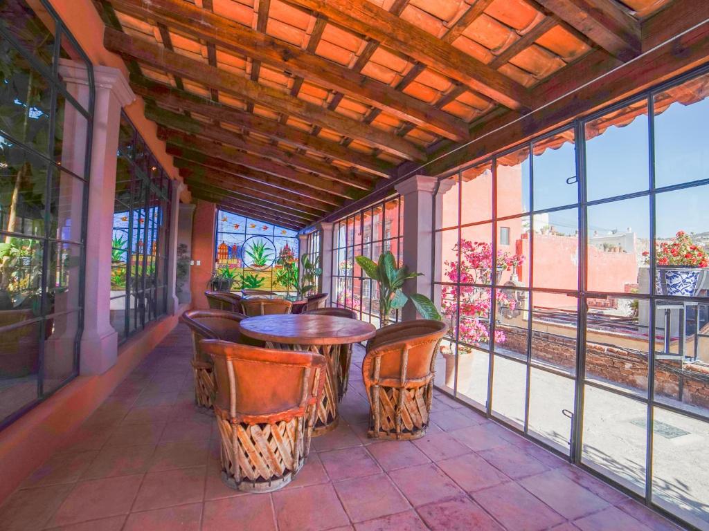 a patio with a table and chairs on a balcony at Hotel Mansión Virreyes by Rotamundos in San Miguel de Allende