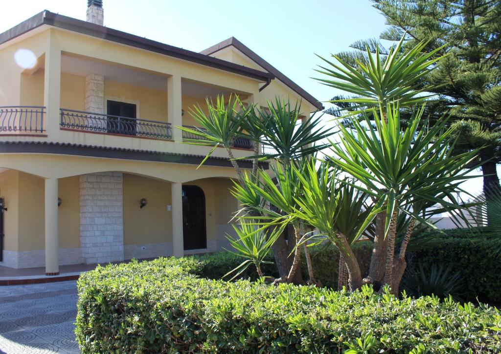 a house with palm trees in front of it at Villa Bice in Pulsano