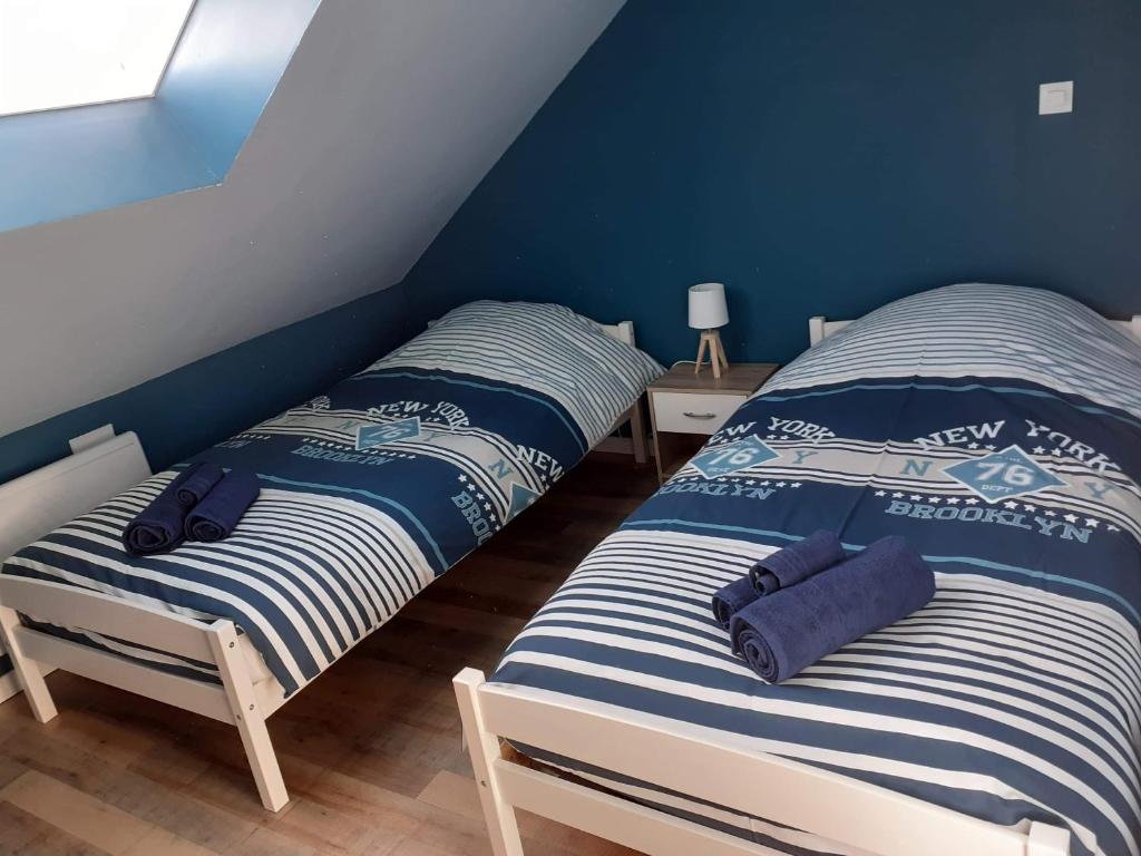 2 camas individuais num quarto com paredes azuis em Villa 27 em Le Tréport