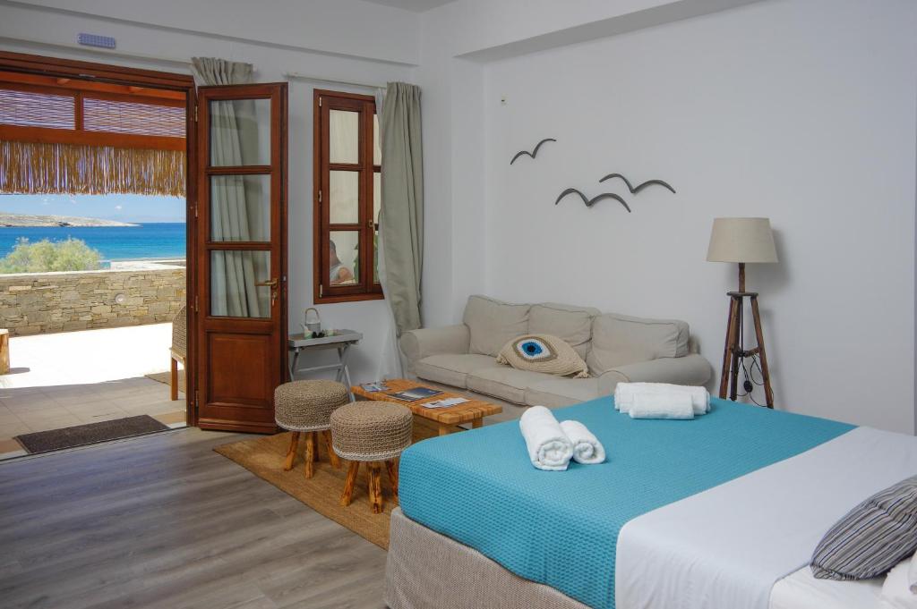 1 dormitorio con 1 cama y sala de estar en Syros Wellness Luxury Suites, en Finikas