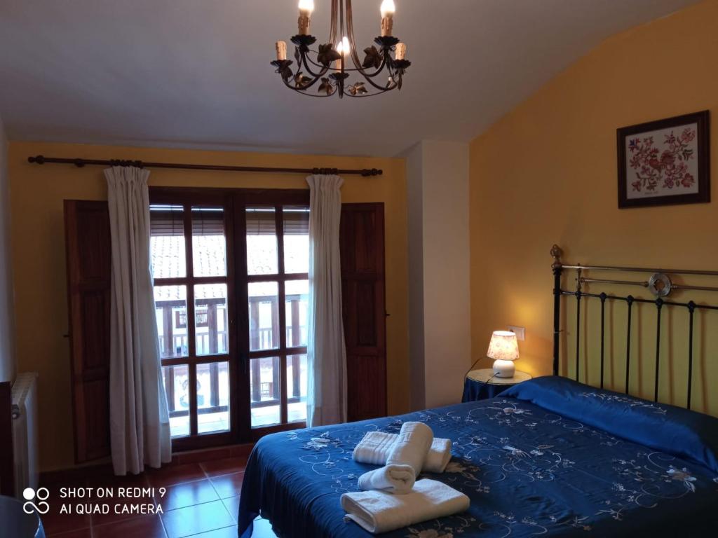 a bedroom with a blue bed with towels on it at El Humilladero in Mogarraz