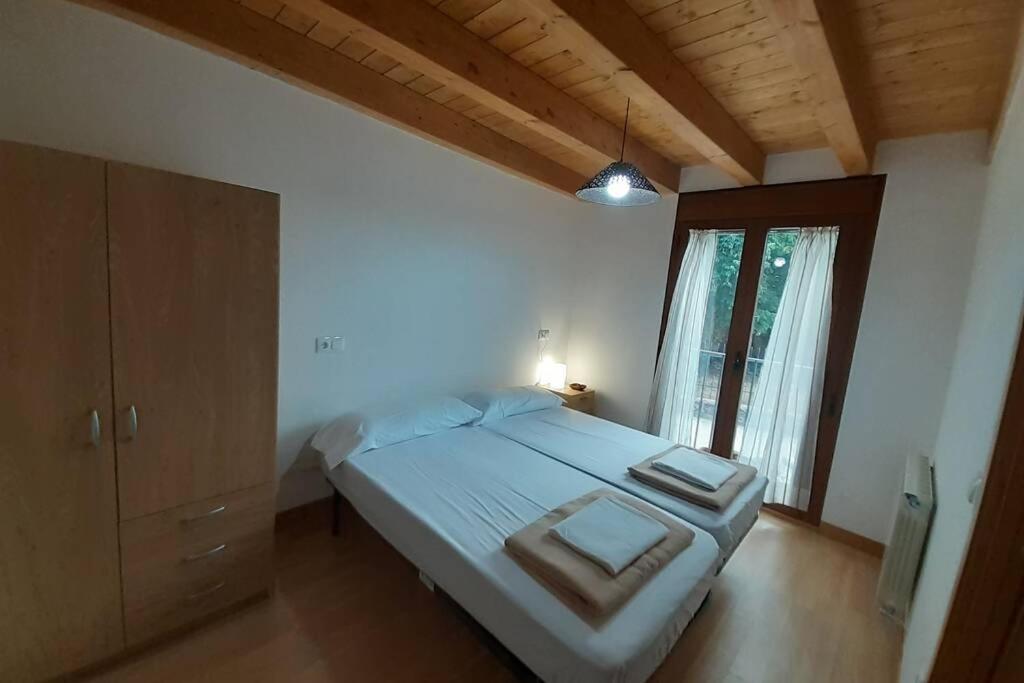 a bedroom with a large bed and a window at Casa Arangol in Pedruel