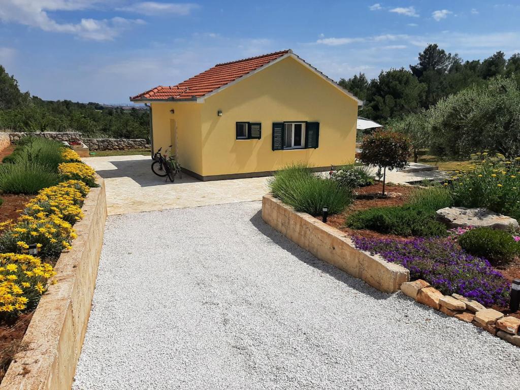 ein kleines gelbes Haus in einem Garten mit Blumen in der Unterkunft Happy garden house in Kožino