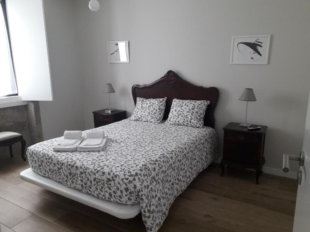 um quarto com uma cama com um edredão preto e branco em Garden House Ramalde no Porto