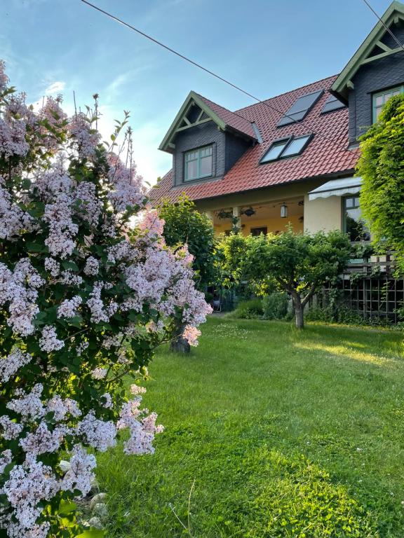 una casa con flores púrpuras en el patio en Ferienhaus Schiller en Waren