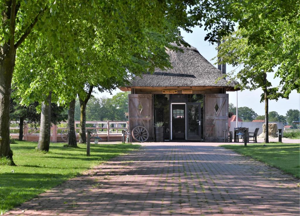 een gebouw in een park met een stenen loopbrug bij Wildwestruurlo in Ruurlo